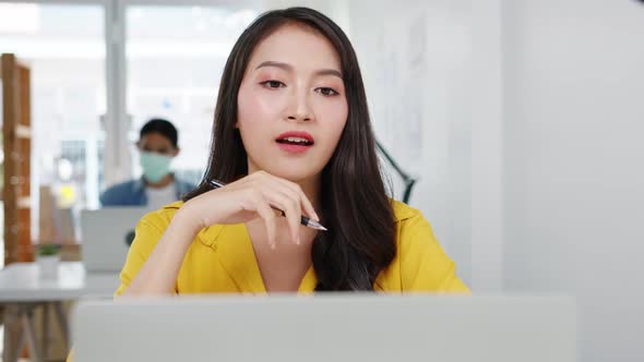 Asia businesswoman social distancing in new normal situation for virus prevention while using laptop