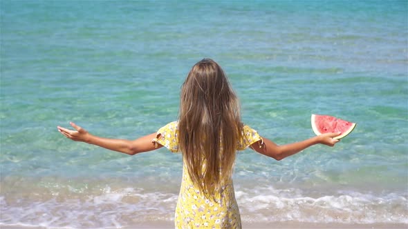 Happy Girl Having Fun on the Beach and Eating Watermelon alt