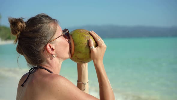 Woman Drinking Fresh Coconut Water on Beach Vacation