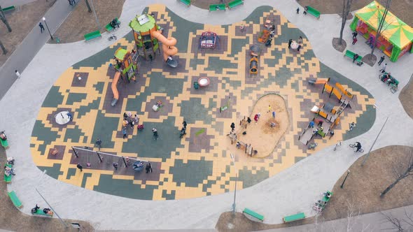 Children Play on the Playground with Swings Carousels and Roller Coasters  Aerial View alt