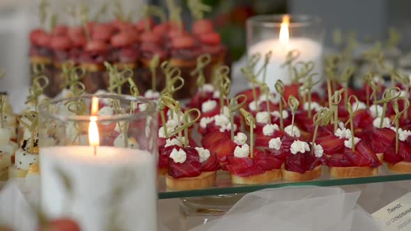 Pinchos with Beetroot on a Glass Stand with Burning Candles