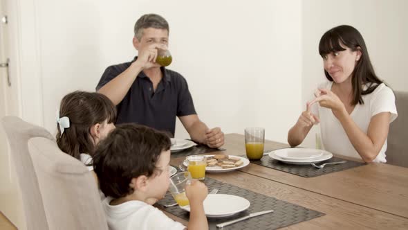 Family Couple and Two Kids Drinking Fresh Orange Juice alt