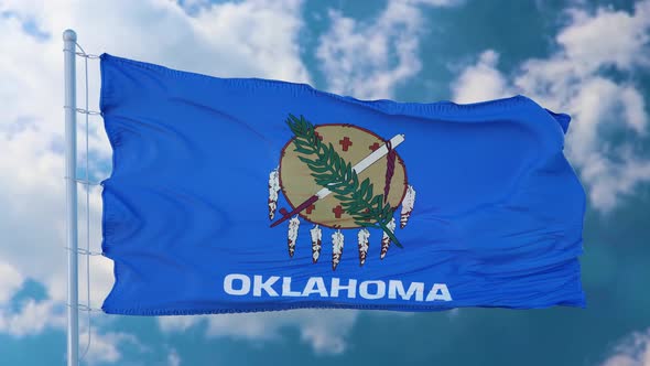 Oklahoma Flag on a Flagpole Waving in the Wind Blue Sky Background alt