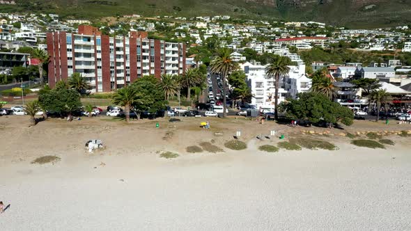 Aerial shot revealing Camps Bay beach and the mountains in the background