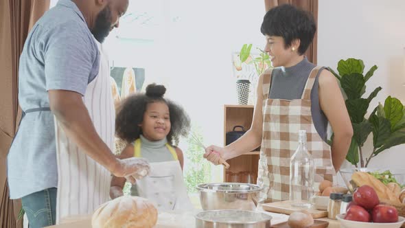 African America family wearing apron thresh flour for cooking and dancing and song together. alt