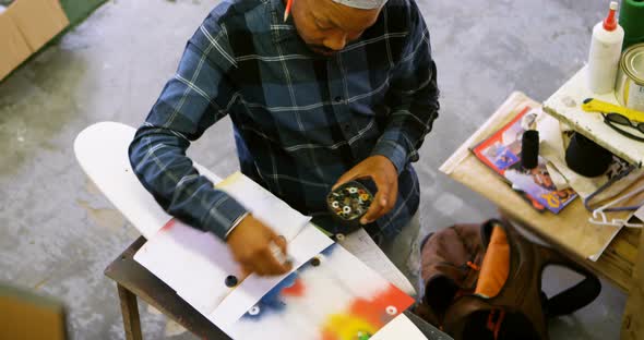 Man using spray painting on a paper  alt