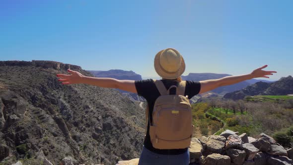 Young Foreign Female Tourist Enjoying the View of Omani Mountains at Jebel Akhdar Gorge in Al Hajar alt