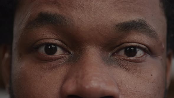 Extreme Closeup of a Surprised Africanamerican Man's Eyes Recieving Good News alt