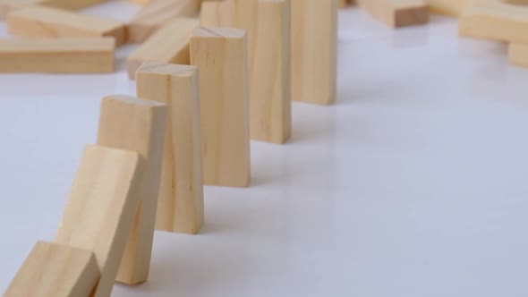 Domino Effect Row of Wooden Domino Falling Down on White Background alt