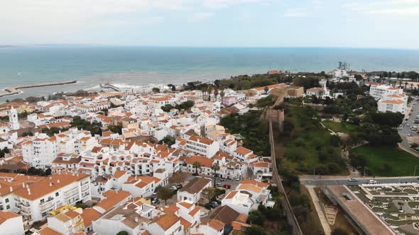 Panoramic view of Lagos old town and Medieval City Walls to Atlantic coast - Aerial Orbit shot alt