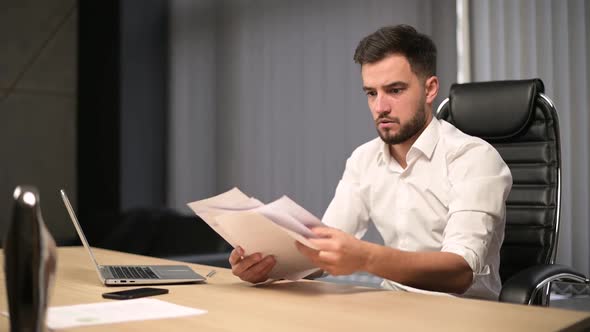 The young executive examines the documents then throws them away, freaking out alt