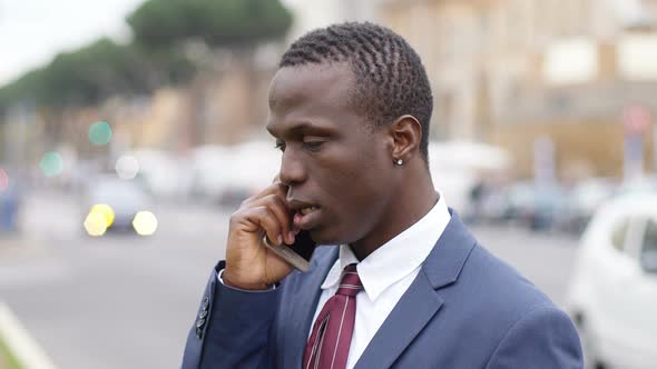 Serious and Worried Black Business Man in The Street Talking by Phone alt