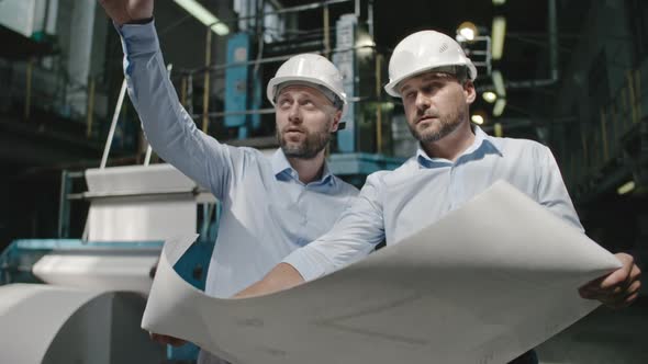 Architects Discussing Factory Layout Plan alt
