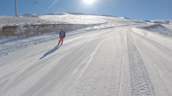 Man skiing on snowy slope at ski resort in the mountains