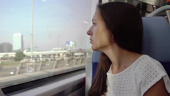 The girl sits in a train by the window