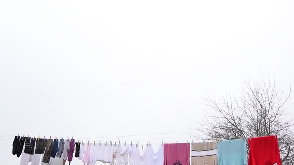 Clothes hanging on an outside washing line drying naturally under an overcast sky. alt