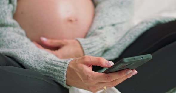 Young Pregnant Woman Scrolling Pictures Phone alt