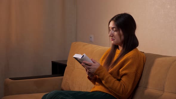 Interested Lady with Long Hair Holds Paper Book and Reads alt