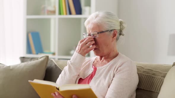 Senior Woman in Glasses Reading Book at Home  alt