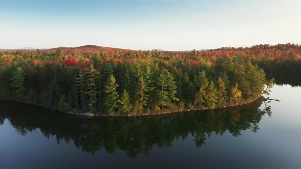 Aerial Small Lake Cinematic Colorful Vibrant Red Orange Forest at Golden Sunset alt