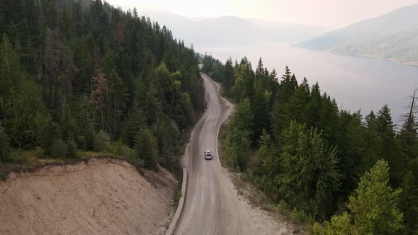 Silver van leaving for an adventurous drive through the vast pine forests of British Columbia. Aeria alt