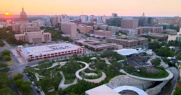 Flying Toward Sunset in Austin, Texas, with view of Capital building and Waterloo Park. Bird's eye v alt