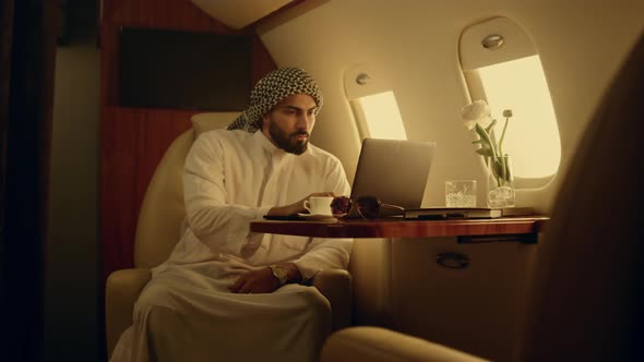 Focused Man Typing Laptop on Jet alt