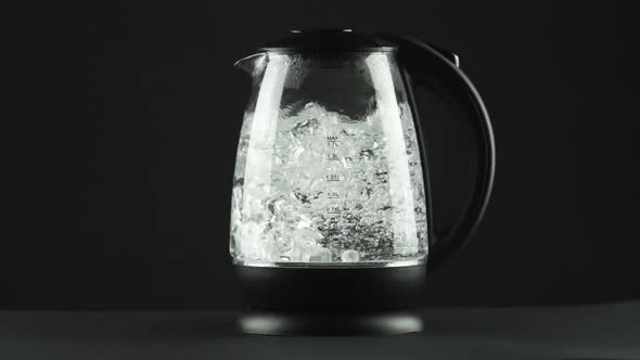 In a Electric Kettle with Transparent Glass Walls, Water Boils, Splashes. alt