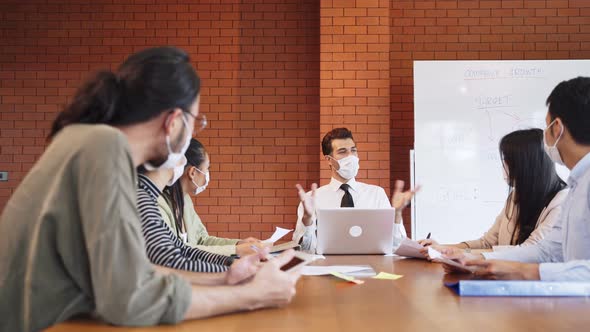 Group of Asian young business people wear face mask and working on computer in office workplace. alt
