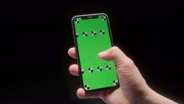 Closeup of a Man Hand Holding Green Mockup Chroma Key Screen Smartphone alt