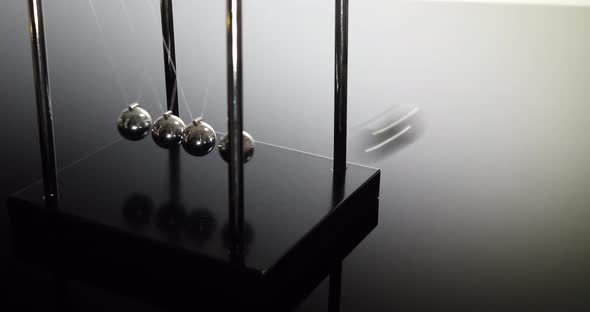 A Newtons cradle demonstrating  laws of physics and the principle of conservation of momentum on a b alt