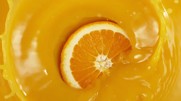 Super Slow Motion Shot of Orange Slice Splashing To Orange Juice at 1000Fps. alt