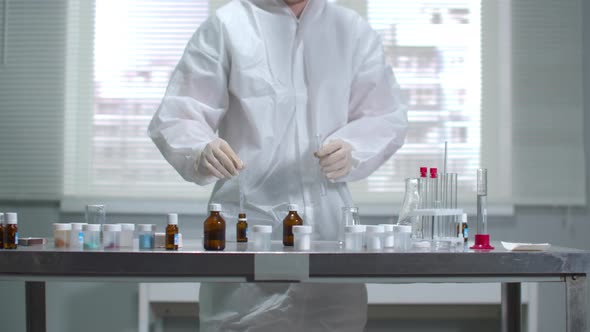 Young Scientist in Protective Workwear and Gloves Work with Chemicals in the Laboratory alt