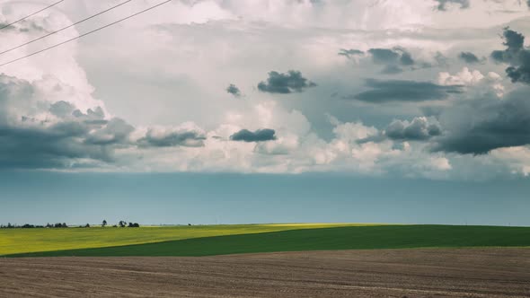 Field In Spring Season. Beginning Of Agricultural Spring Season. Tractor Raised Dust From Field alt