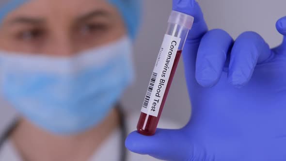Nurse Holding Test Tube with Positive Coronavirus Test Blood