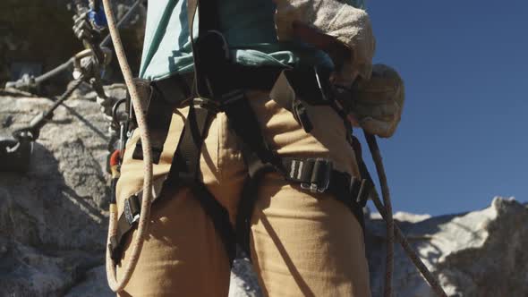 Young Caucasian man fastening zip lining harness alt