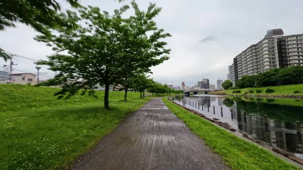 4k Shot of green trees and river by the  Kasai Rinkai Park in the city of Tokyo, Japan. alt