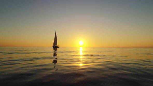 Spain Sunset over the Horizon While Sailboat is Floating alt