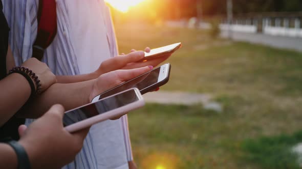 Three Persons Use Smartphones on the Street alt