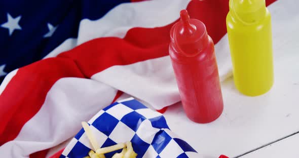Hot dog, french fries and cold drink served on a table with 4th july theme alt