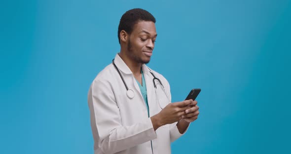 Medical Chat. Young Doctor Texting with Patient on Cellphone and Smiling, Modern Communicatio alt