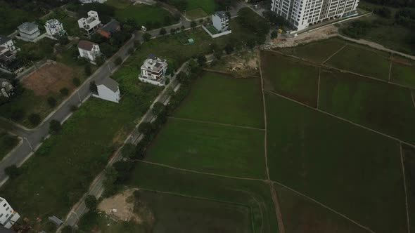 drone shot of rice fields and new villa and high rise development on the outskirts of Ho Chi Minh Ci alt