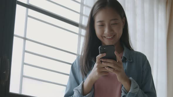 Asian businesswoman holding typing mobile phone.