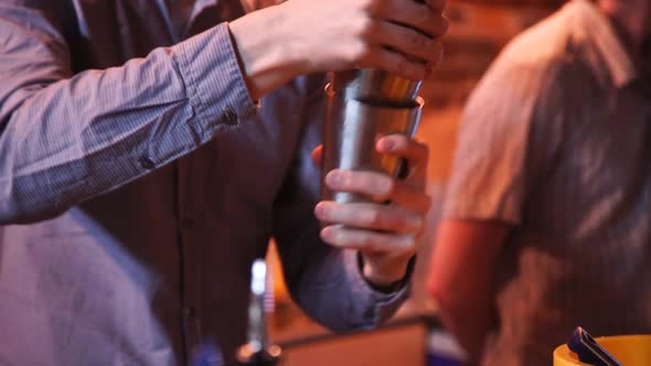 Barmen with Shaker Pouring Cocktail Into Glass 2 alt
