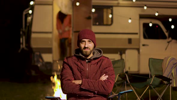 Portrait of Bearded Young Man Sitting on a Chair Looking at the Camera alt
