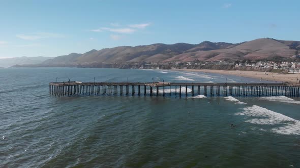 Drone flies along Pismo Beach Pier in San Luis Obispo on a Sunny Summer Day