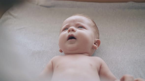 Boy with Short Hair Lies on Table and Nurse Makes Massage alt