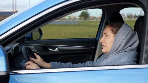 Stressed and Depressed Woman Hits Steering Wheel with Head alt