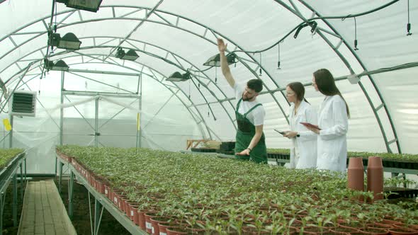 Farmer Showing Growing Crops To Scientists