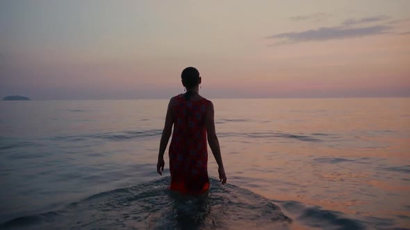 a Female Figure Going Into the Sea at Sunset